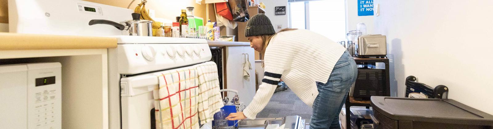 Student unloading dishwasher in her dorm