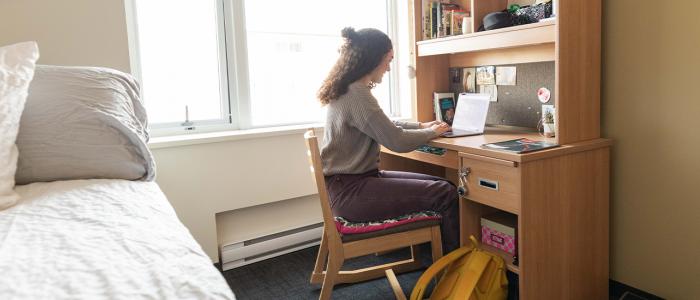 UBC student in her dormitory at her desk studying