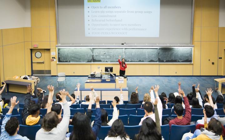 Students raising their hands at a UBC A Cappella meeting.